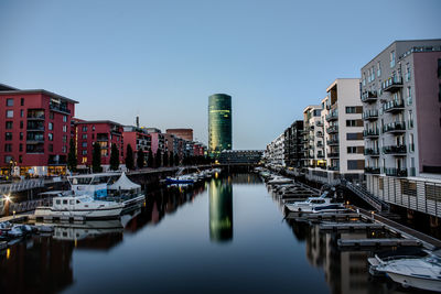 Bridge over river amidst buildings against sky in city in frankfurt, germany 