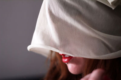 Close-up of woman covering face against wall