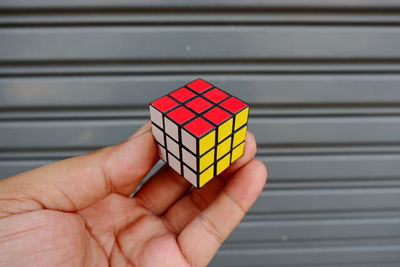 Cropped hand of person holding puzzle cube