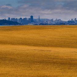 View of cityscape against cloudy sky