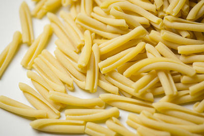 Close-up of raw pasta over white background