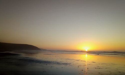 Scenic view of sea against clear sky during sunset