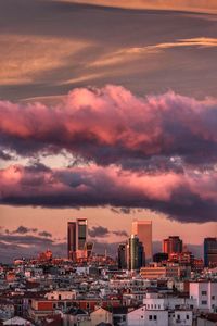 Cityscape against dramatic sky during sunset