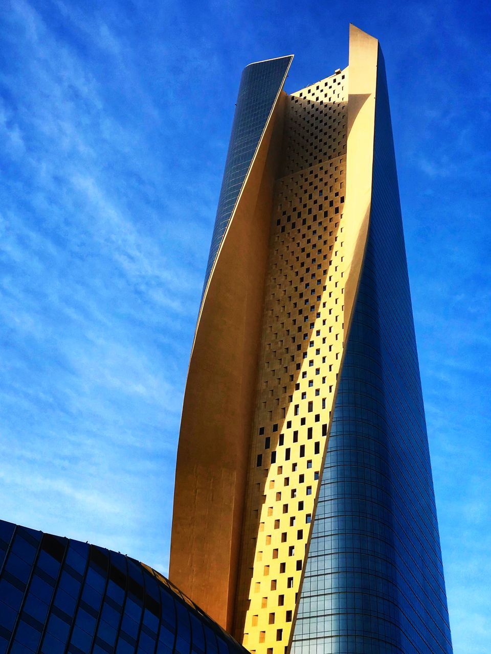 LOW ANGLE VIEW OF OFFICE BUILDING AGAINST BLUE SKY