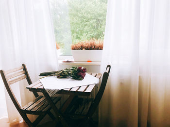 Chairs and table arranged by window at home