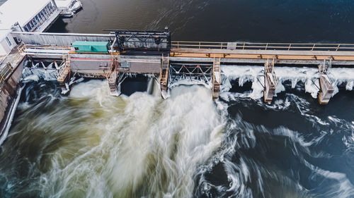 Water is rushing at the dam in winter as spring approaches with extended exposure settings