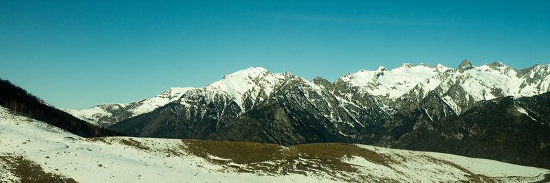 Scenic view of snowcapped mountains against clear sky