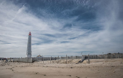 Tower on beach against sky