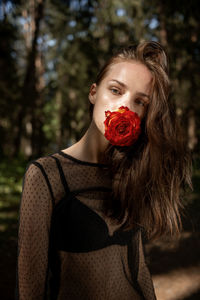 Portrait of young woman holding heart shape