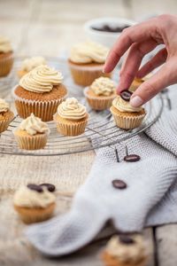 Cropped image of hand preparing cupcakes