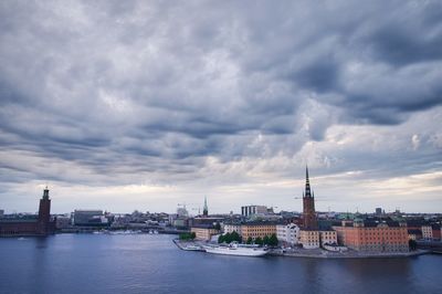 Buildings in city against cloudy sky