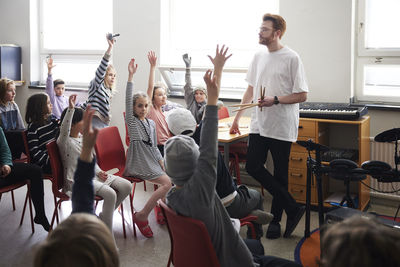 Children raising hands in class