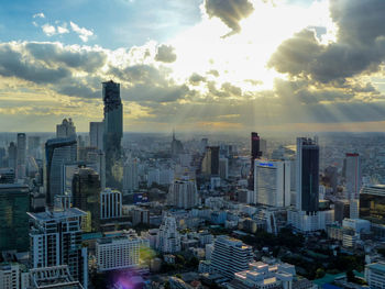 Aerial view of buildings in city against sky during sunset