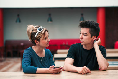 Mother looking at tensed son in restaurant