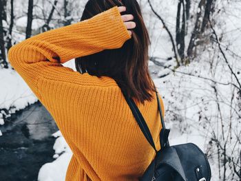 Midsection of woman by tree during winter