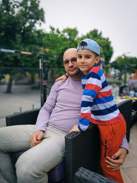 Portrait of father with son on seat