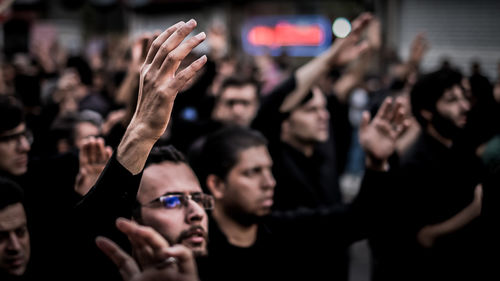 Midsection of woman with arms raised in background