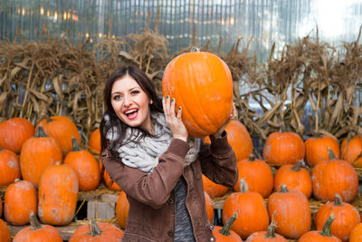 Portrait of a smiling young woman with pumpkins