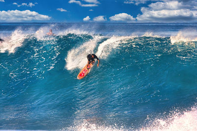 Man surfing on sea against sky