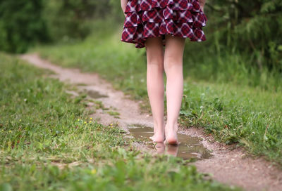 Low section of woman standing on field