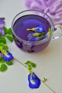 Close-up of purple flower in glass container on table