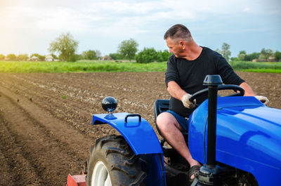 A farmer on a tractor works in the field. freeing milling earth ground from old crops. 