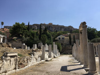 Remains of the roman agora in athens with the acropolis seen in the background.