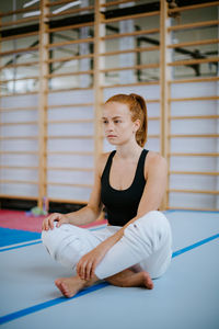 Thoughtful woman sitting in gym