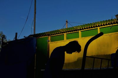 Low angle view of silhouette bridge against clear blue sky