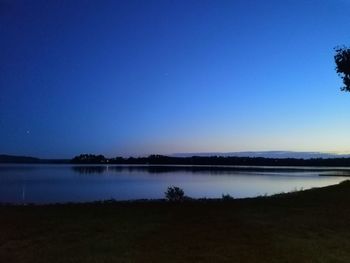 Scenic view of lake against clear blue sky at night