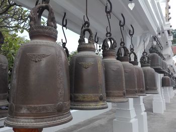 Low angle view of old metal hanging against wall