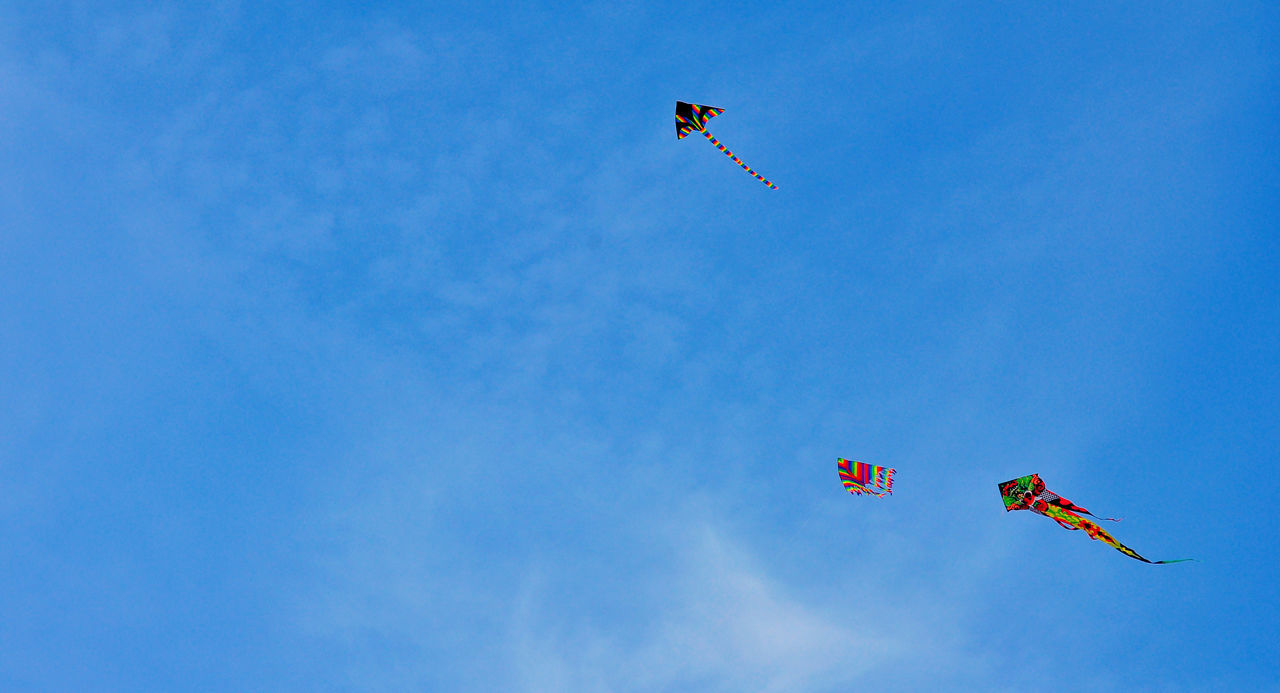 flying, mid-air, low angle view, transportation, air vehicle, mode of transport, blue, airplane, parachute, extreme sports, kite - toy, adventure, motion, airshow, clear sky, on the move, sky, freedom, paragliding, copy space