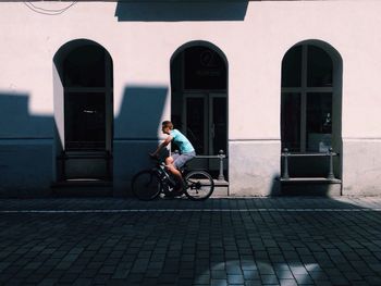 Man riding bicycle on street in city
