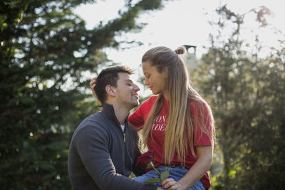 Rear view of couple kissing against trees