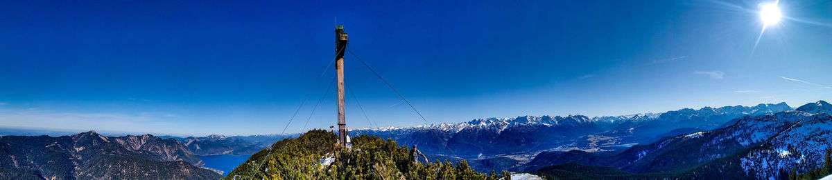 Low angle view of snowcapped mountains against blue sky