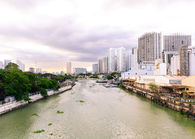 Bridge over river in city against sky