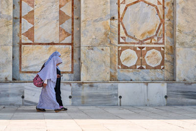 Rear view of woman against wall