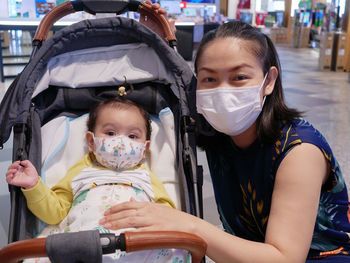 Portrait of mother and daughter wearing mask outdoors