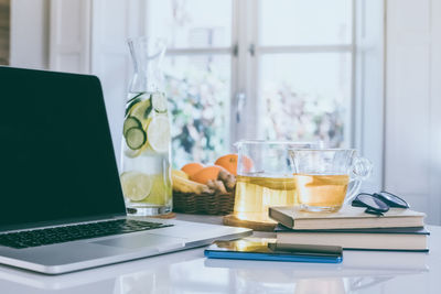 Morning time, healthy breakfast laptop and drink on table. natural meal, fruits in remote office