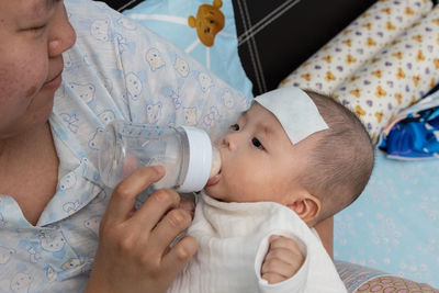 Midsection of baby girl lying on bed