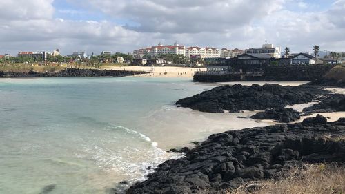 Panoramic view of sea and buildings against sky