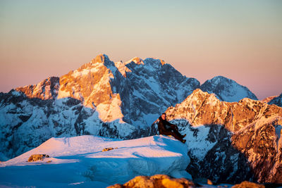 Scenic view of snowcapped mountains against clear sky during sunset