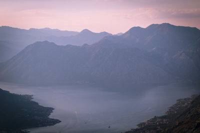 Scenic view of lake and mountains against sky during sunset