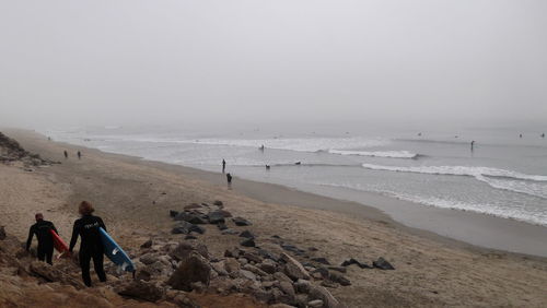 People on beach against sky