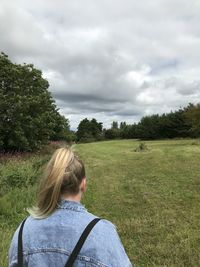 Rear view of woman on field against sky