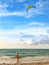 Rear view of person with umbrella on beach