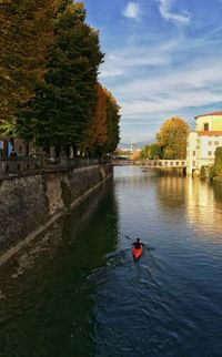 Rear view of man canoeing in canal