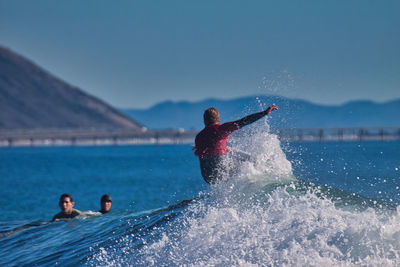 Man surfing on sea against sky