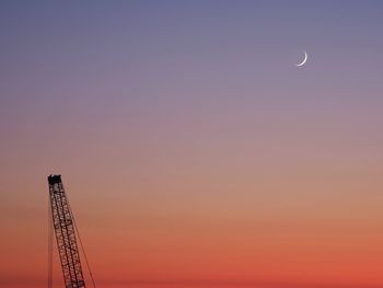 Low angle view of silhouette moon against sky at sunset