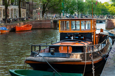 Boat moored in canal by trees